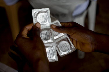 A participant in a training course holds packets of condoms during a Capacity Building Training forum for Male Advocates, Peer Educators and Community Advocacy Groups (CAGS). The training consists of...