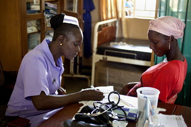 Sia Sandi, a student midwife from The School of Midwifery in Masuba, takes notes from a pregnant patient while on placement at the Makeni Regional Hospital. Her training is being funded by H4+ (made u...
