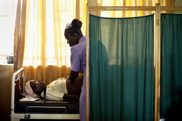 Sia Sandi, a student midwife from The School of Midwifery in Masuba, examines a pregnant patient while on placement at the Makeni Regional Hospital. Her training is being funded by H4+ (made up of UNA...