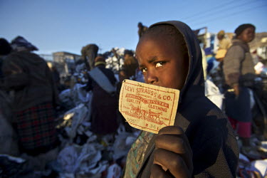 A boy holds a label of a pair of Levi Strauss jeans at the Ha Tsosane rubbish dump in Maseru. Major western garment companies including GAP and Levis have set up manufacturing plants in Lesotho. They...