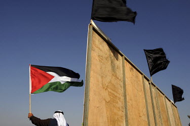 A man waves a Palestinian flag during a 'Land Day' rally in the unrecognised Bedouin settlement of al Arakib (al Araqeeb) in Israel's southern Negev desert. 'Land Day' is an annual event held Israeli...