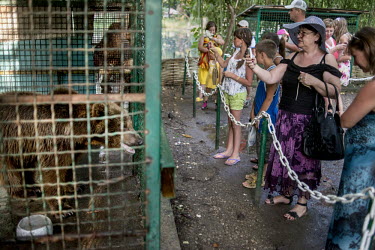 Tourists take pictures and look at the caged bears at a small zoo in the seaside resort of Gagra, the busiest resort on Abkhazia's coast.