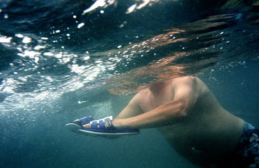 A man uses his shoes to swim in the Black Sea near Pitsunda.