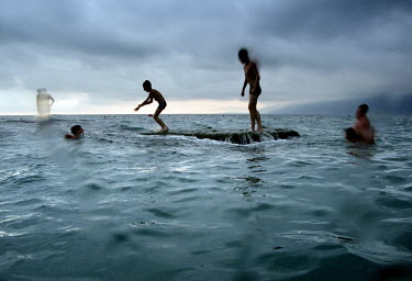 Children use a partially submerged block of concrete as a platform to dive into the sea near a beach in Gagra, Abkhazia's busiest Black Sea resort.