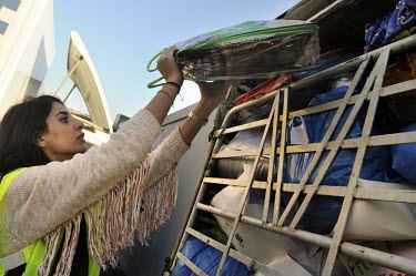 A volunteer sorts through bags of donnated clothes and blankets at an outdoor collection point in Beirut. The campaign 'I Am Not A Tourist' was set up by Tanya Khalil, a student at the theatre academy...