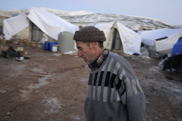 An elderly man walks past makeshift shelters in a refugee camp for Syrian refugees in the Bekaa (Beqaa) Valley in Lebanon. Since the beginning of the civil war in Syria, some 880,000 Syrians have fled...