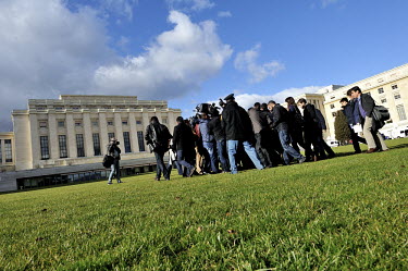 Members of the international media surround Syrian opposition figure Najib Ghadban outside the Palais des Nations, before the opposition meeting with Special Representative Brahimi during the Geneva I...
