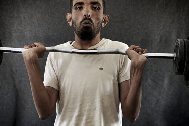 A man using the weighlifting equipment in the Mens Activity Centre, set up by Save the Children, in the Za'atari refugee camp for refugees who have fled the fighting in neighbouring Syria. In July 201...
