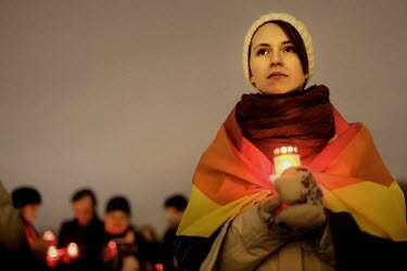 18 year old Vika Skuetsova, wrapped in a rainbow flag and holding a candle, at an event commemorating LGBT victims of homophobic violence in Russia. Vika is bisexual and is a student studying economy...