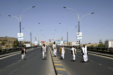 A group of men walk on a highway during a funeral for 12 protestors killed by pro-President Salah troops during recent anti-government protests. The 33 year rule of authoritarian president, Ali Abdull...