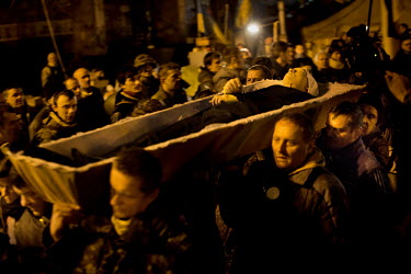 Men carry the coffin of one of the dozens of protesters who died in clashes police in Kiev. Protests against the government of President Viktor Yanukovych were sparked on 21 November 2013 by the Ukrai...