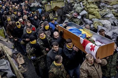 Men carry the coffin of one of the dozens of protesters who died in clashes with police in Kiev on 20 February 2014 to the barricades in a final tribute. Protests against the government of President V...