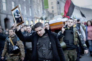 The funeral cortege of an activist, led by a man who holds aloft a photograph of the dead man, one of dozens who died in clashes with police on 20 February 2014 on and around Maidan Nezalezhnosti (Ind...