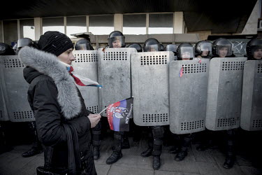 At a rally in front of Donetsk Oblast Administrative building, pro-russian activists are confronted with a massive police force that's there to deter further riots. A woman walks past the column of po...