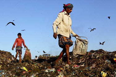 A man and a boy look for recyclable material at the biggest rubbish dump in Dhaka. The city alone generates about 3500 to 4000 metric tons of solid waste each day.