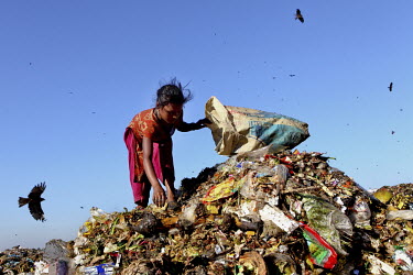 A girl look for recyclable material, to sell at a market, at the biggest rubbish dump in Dhaka. The city alone generates about 3500 to 4000 metric tons of solid waste each day.