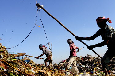 Workers spread out rubbish at a huge dump after it was unloaded from a truck. Dhaka alone generates about 3500 to 4000 metric tons of solid waste each day.