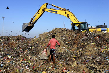 A young man looks for recyclable material at the biggest rubbish dump in Dhaka. The city alone generates about 3500 to 4000 metric tons of solid waste each day.