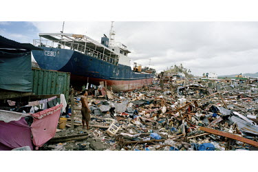 A man stands near a beached ship in a scene of mass devastation in Tacloban city after Typhoon Haiyan swept through the Philippines. Typhoon Haiyan, or Yolanda as it is known in the Philippines, made...