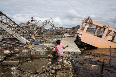 A boy plays among the devastation beside the ocean in Tacloban after Typhoon Haiyan swept through the Philippines. Typhoon Haiyan, or Yolanda as it is known in the Philippines, made landfall on 8 Nove...