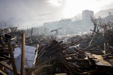 A man carries wood through a scene of mass devastation in Tacloban after Tphoon Haiyan swept through the Philippines. Typhoon Haiyan, or Yolanda as it is known in the Philippines, made landfall on 8 N...
