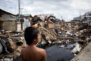 A boy looks over a scene of mass devastation in Tacloban city after Typhoon Haiyan swept through the Philippines. Typhoon Haiyan, or Yolanda as it is known in the Philippines, made landfall on 8 Novem...