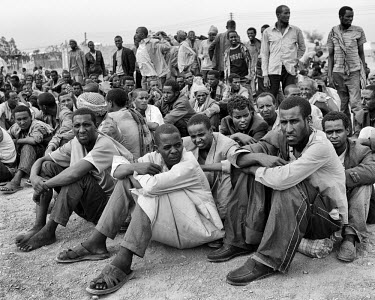A large group of newly arrived men, mostly from Somalia, wait to be processed at Kharaz refugee camp. The camp holds roughly 15,000 people and is sited deep in the desert 136 kilometres from Aden. The...