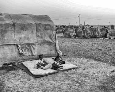 Three young children lie on matresses outside a tent in in Kharaz refugee camp where summer temperatures can reach 50 degrees Celsius. The camp holds roughly 15,000 mostly Somali migrants, half of who...