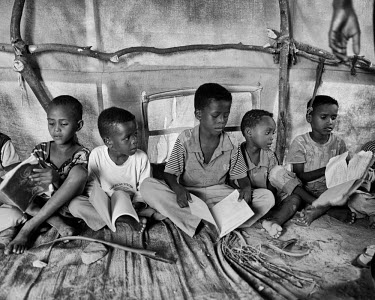 A group of boys sit on the floor of a tent that is used as a school in Kharaz refugee camp. The camp holds roughly 15,000 mostly Somali migrants, half of whom are children. The United Nations Refugee...