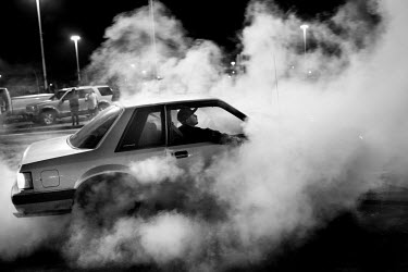 A man burns rubber during a 7th Street Sideshow, an illegal gathering of car and motorbike enthusiasts who come together to perform stunts and hold street drag races. In the Bay Area, deep in East Oak...