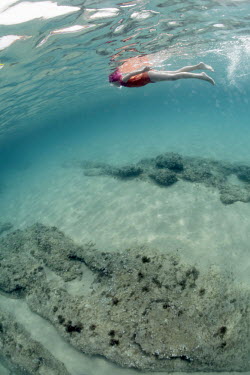 A girl snorkels in the clear Mediterranean waters off the north coast of Sardinia.