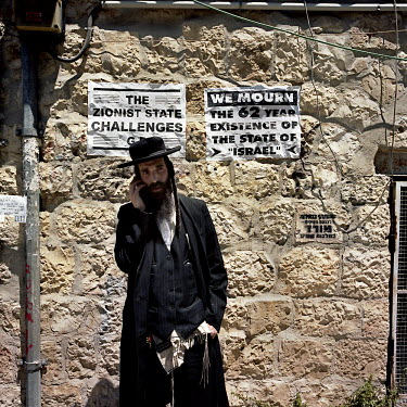 Yoel Kroiz, a prominent figure in the anti-Zionist, anti-state of Israel group calledNeturei Karta(Guardians of the City), stands beside some of the group's posters in the Ultra Orthodox neighbourhood...