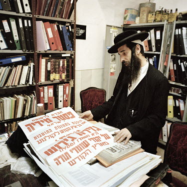 Yoel Kroiz, a prominent figure in the anti-Zionist, anti-state of Israel group calledNeturei Karta(Guardians of the City), shows some of the group's posters at their offices in the Ultra Orthodox neig...