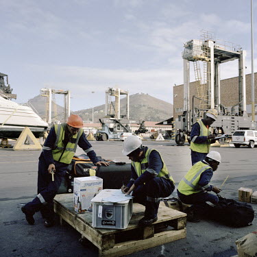 Dock workers in Cape Town prepare to load the passenger's baggage onto the RMS St Helena. There are only two remaining Royal Mail Ships, the other being Cunard's Queen Mary 2. The RMS St Helena is the...