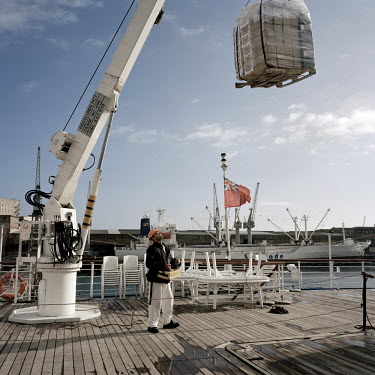 Dock workers in Cape Town load the RMS St Helena with cargo. There are only two remaining Royal Mail Ships, the other being Cunard's Queen Mary 2. The RMS St Helena is the only link to the outside wor...