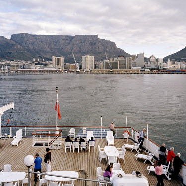 Passengers watch on deck as the RMS St Helena leaves Cape Town. There are only two remaining Royal Mail Ships, the other being Cunard's Queen Mary 2. The RMS St Helena is the only link to the outside...