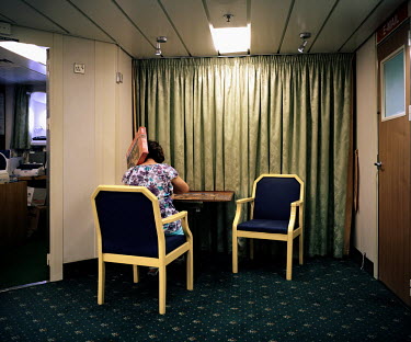 A passenger onboard the RMS St Helena works on a jigsaw puzzle. There are only two remaining Royal Mail Ships, the other being Cunard's Queen Mary 2. The RMS St Helena is the only link to the outside...