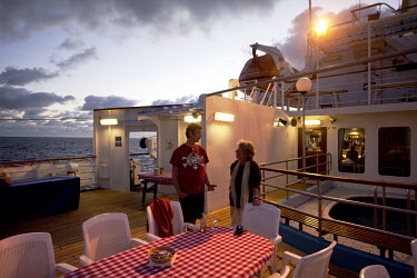 Oyvind Haugseth and Susan Lea , passengers on the RMS St Helena, taking in the sunset on the sun deck. There are only two remaining Royal Mail Ships, the other being Cunard's Queen Mary 2. The RMS St...