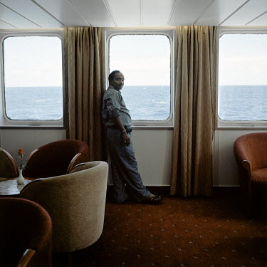 A tourist on the RMS St Helena looks out to sea. There are only two remaining Royal Mail Ships, the other being Cunard's Queen Mary 2. The RMS St Helena is the only link to the outside world for the i...