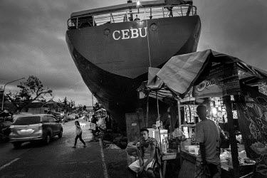 A street stall beside a washed up ship on a road cleared of debris 10 weeks after Typhoon Haiyan, or Yolanda as it is known in the Philippines, made landfall on 8 November 2013. The ship has been turn...