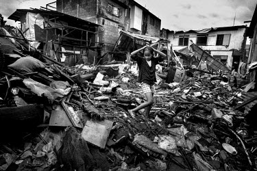 A young girl walks across a pile of debris. Typhoon Haiyan, or Yolanda as it is known in the Philippines, made landfall on 8 November 2013 and was one of the deadliest typhoons to hit the Philippines,...