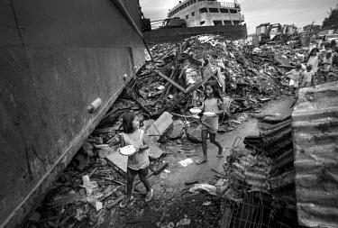 Children head home, on a path cleared through the debris, carrying food handed out by UNICEF. Typhoon Haiyan, or Yolanda as it is known in the Philippines, made landfall on 8 November 2013 and was one...