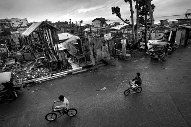 Boys riding their bikes along a road cleared of debris following Typhoon Haiyan. Typhoon Haiyan, or Yolanda as it is known in the Philippines, made landfall on 8 November 2013 and was one of the deadl...