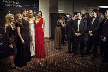 WAGS of Team Ralph Lauren players pose for photographers as their admiring partners look on prior to the Gala Dinner for the 30th Polo on Snow World Cup at the Kempinski Grand Hotel des Bains.