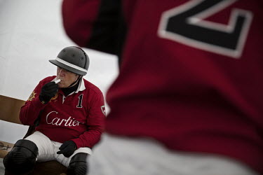 Team Cartier patron Jonathan Munro Ford applies lip protector in the team tent before the semi-final of the 30th Polo on Snow World Cup. In polo the team patron is an amateur player who pays for the t...