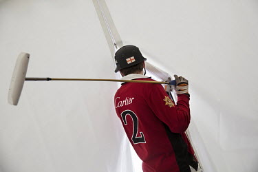 English polo player, Max Charlton, looks out from the Team Cartier tent prior to the semi-final match at the 30th Polo on Snow World Cup .