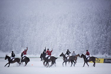 Riders and horses from Team Ralph Lauren and Team Cartier jostle for posession of the ball during the final of the 30th Polo on Snow World Cup.