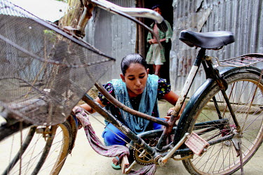 Info Lady, Shathi, cleaning her bicycle. In rural Bangladesh the Info Ladies are bringing internet services to men and women who need information but don’t have the means to access the web. After th...