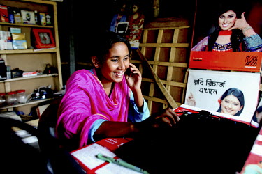 Info Lady Shathi surfing the net in her family's shop where she is also availble for those seeking internet and information services. In rural Bangladesh the Info Ladies are bringing internet services...