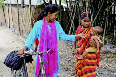 Info Lady Farhana talks to a women and her baby during her rounds of rural villages. In rural Bangladesh the Info Ladies are bringing internet services to men and women who need information but don’...